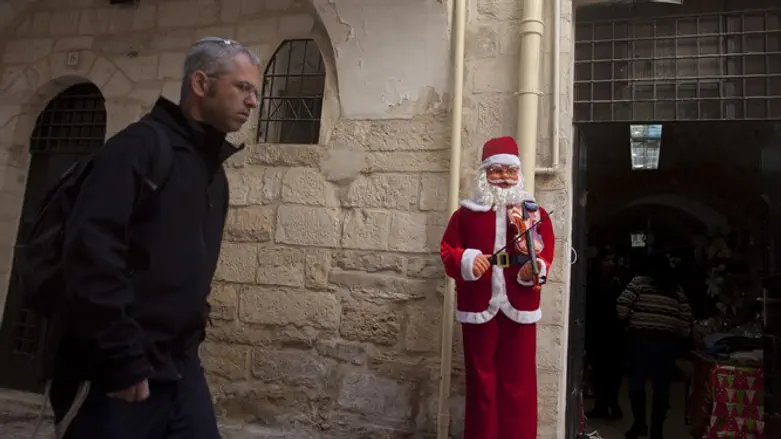 A Jewish man walks next to a Santa Claus doll for Christmas in a shop in Jerusalem's Old