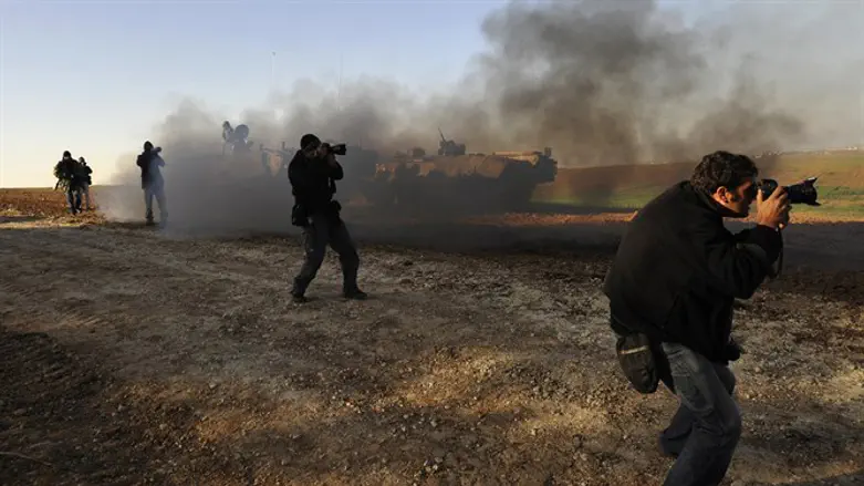 Foreign photographers take pictures of Israeli troops outside northern Gaza