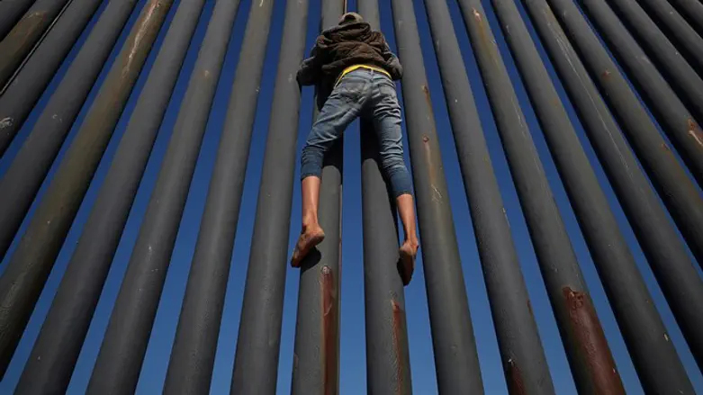 Climbing border fence between Mexico and United States in Tijuana
