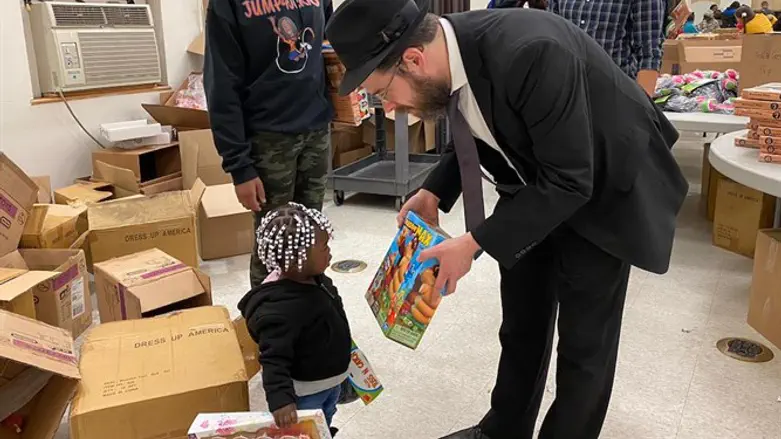 Rabbi Moshe Schapiro shows a toy to a child during the charity drive in Jersey City
