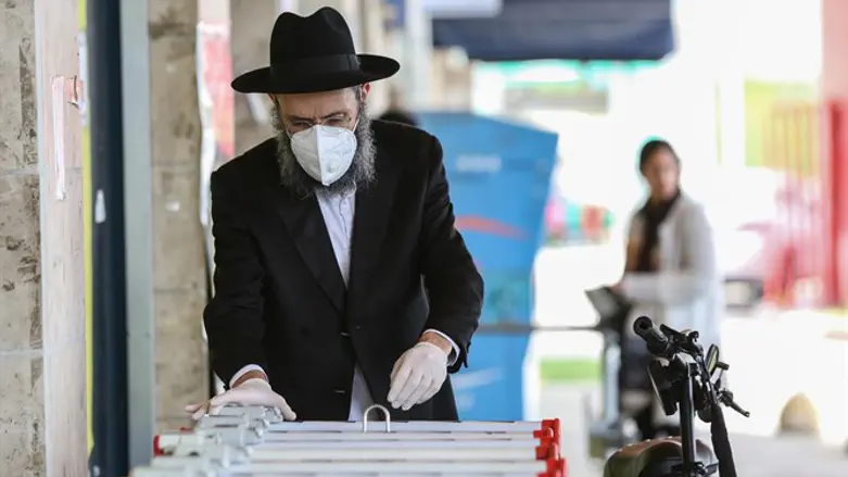 Haredi man wears face mask and gloves as he shops in northern Israel