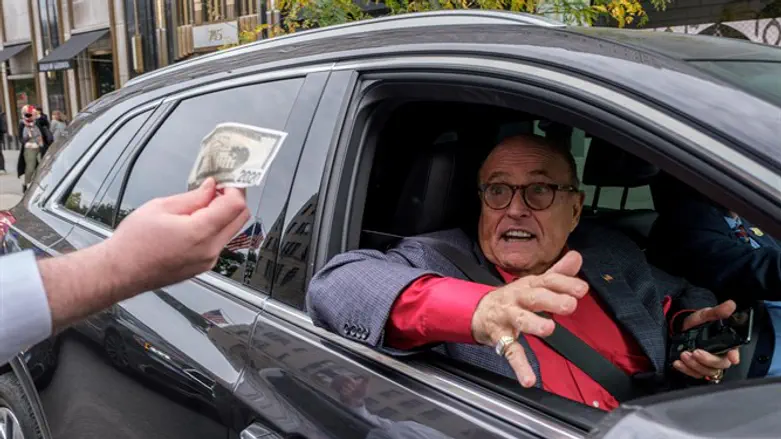 Former New York City Mayor Rudy Giuliani drives by protest